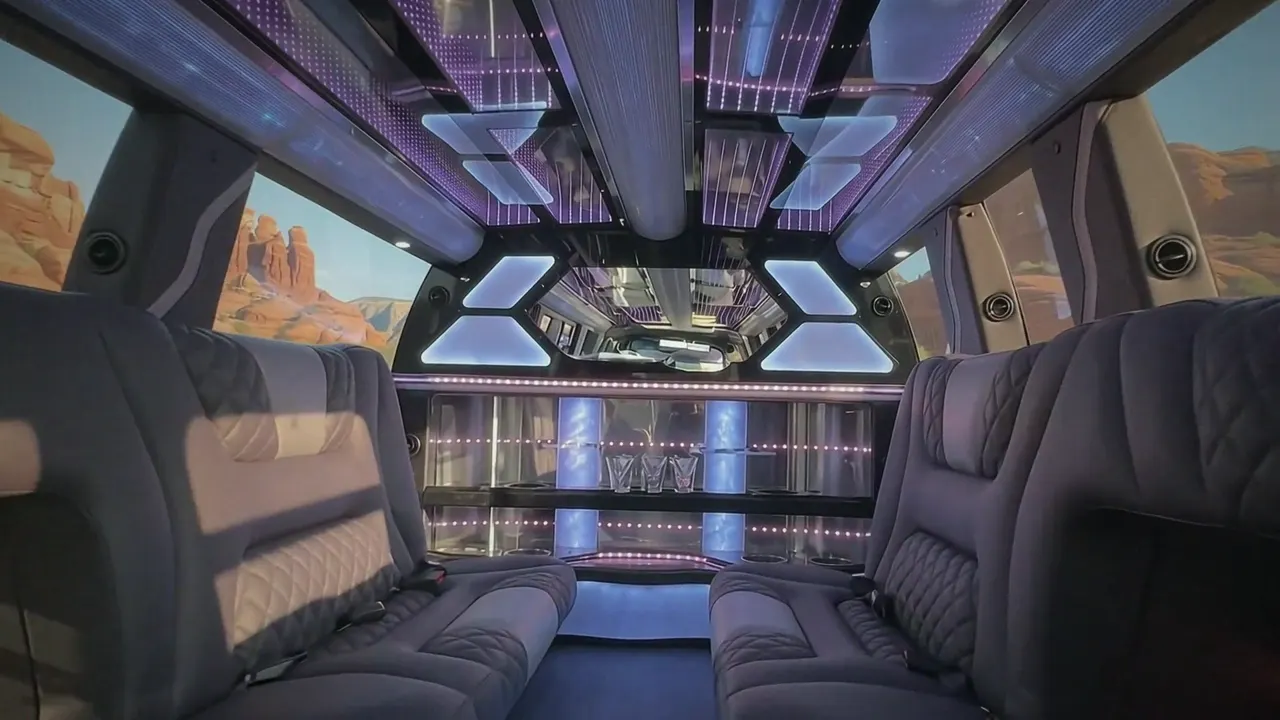 Inside the Cadillac Escalade limo in Monument: LED light-show ceiling, leather lounge seating and lit bar